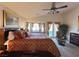 Spacious main bedroom featuring a ceiling fan, reading chair, and a bay window with curtains at 2710 Mustang Pass St, Laughlin, NV 89029