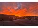 A vibrant sunset illuminates the street and homes in this picturesque neighborhood scene at 2710 Mustang Pass St, Laughlin, NV 89029