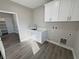 Bright laundry room with white cabinets and view to another room at 2750 Zephyr Ave, Pahrump, NV 89048