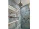 Luxury shower with marble tile, built-in shelving, and rain shower head at 2750 Zephyr Ave, Pahrump, NV 89048