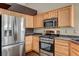 Kitchen with stainless steel appliances, light wood cabinetry and dark countertops at 5217 Yellow Dawn Ct, Las Vegas, NV 89130