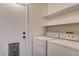 Convenient laundry area with washer, dryer, storage shelves, and easy access to the outside at 5217 Yellow Dawn Ct, Las Vegas, NV 89130