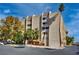 Exterior view of a residential building with a parking lot and mature trees on a sunny day at 730 S Royal Crest Cir # 421, Las Vegas, NV 89169