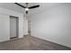 Spacious bedroom with ceiling fan, gray carpet, and sliding closet doors at 303 Vallarte Dr, Henderson, NV 89014