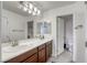 Double vanity bathroom featuring modern fixtures, a large mirror, and plenty of storage space at 7579 Harwich Bay Ave, Las Vegas, NV 89179