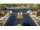 Community entrance aerial view, showing decorative wreaths adorning the gate, desert landscaping, and paved roadway at 7579 Harwich Bay Ave, Las Vegas, NV 89179