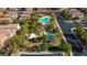 Aerial view of a community park with a pool, playground, picnic area, lush landscaping, and parking, surrounded by homes at 7579 Harwich Bay Ave, Las Vegas, NV 89179