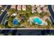 Aerial view of a community pool, playground, and covered picnic area surrounded by mature trees and well-kept homes at 7579 Harwich Bay Ave, Las Vegas, NV 89179