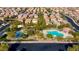 Aerial view of a community pool, playground, and covered picnic area surrounded by mature trees and well-kept homes at 7579 Harwich Bay Ave, Las Vegas, NV 89179