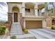 Front of a two-story home showcasing a two-car garage and landscaping at 7579 Harwich Bay Ave, Las Vegas, NV 89179