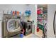 Well-equipped laundry room featuring modern washer and dryer units with storage shelves at 7579 Harwich Bay Ave, Las Vegas, NV 89179