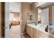 Bright bathroom featuring double sinks, vanity and door leading to bedroom at 10234 Renae Nicole Ct, Las Vegas, NV 89183