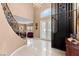 Grand foyer with staircase, wrought iron railings, chandelier, elevator, and tile flooring at 10234 Renae Nicole Ct, Las Vegas, NV 89183