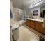 Bathroom featuring double sinks, good lighting, tub/shower combo, and wood cabinets at 11177 Deluna St, Las Vegas, NV 89141