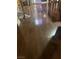 Warm-toned hardwood flooring extending to the kitchen with barstools and dining chairs at 11177 Deluna St, Las Vegas, NV 89141