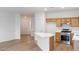 Open kitchen with a white countertop island and stainless steel appliances, complemented by modern vinyl floors at 7936 Pinnochio Ave, Las Vegas, NV 89131