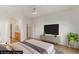 Staged main bedroom with ceiling fan, large television, ensuite bathroom, and closet at 7936 Pinnochio Ave, Las Vegas, NV 89131