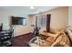 Living room featuring a sectional sofa, exercise bike, and large TV at 9790 Overlook Ridge Ave, Las Vegas, NV 89148