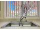 Kitchen sink under the window overlooking blossoming fruit trees in the yard at 3013 Sungold Dr, Las Vegas, NV 89134