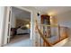 Upstairs hallway offers a view into a bedroom and features a wooden staircase and railing at 3490 S Adobe Ct, Pahrump, NV 89048
