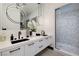 Modern bathroom with dual sinks, contemporary lighting, and a textured shower at 500 Overlook Rim Dr, Henderson, NV 89012