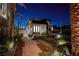 Striking two-story home with lush landscaping and a modern facade at twilight at 500 Overlook Rim Dr, Henderson, NV 89012