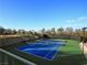 Well-maintained tennis court with vibrant blue surface, surrounded by trees and spectator seating at 500 Overlook Rim Dr, Henderson, NV 89012
