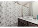 This bathroom features a large mirror, a pedestal sink, and a shower with a floral curtain at 8934 Windgate Ranch St, Las Vegas, NV 89166