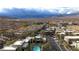 Aerial view of a well-maintained community featuring lush landscaping, mountain views and pool area at 11236 Rainbow Peak Ave # 210, Las Vegas, NV 89135