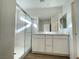 Well-lit bathroom featuring dual sinks, shower with glass door, and modern fixtures at 2723 Luzzi Walk, Henderson, NV 89044