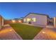 Backyard featuring artificial grass, pavers, gravel, and night lighting at 617 Sylvan St, Henderson, NV 89002