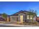 A cozy single-story home featuring desert landscaping and a brick driveway, bathed in the soft glow of twilight at 617 Sylvan St, Henderson, NV 89002