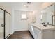 Modern bathroom with double vanity, dark fixtures, and a glass enclosed shower at 9881 Lost Horse Ave, Las Vegas, NV 89178