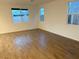 Spacious living room with wood-look tile floor and multiple windows at 5076 Dule Grove St, Las Vegas, NV 89130