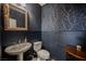 Chic powder room featuring elegant wallpaper, a pedestal sink, and a decorative mirror at 35 Flora Sagio Ave, Henderson, NV 89011