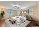 A staged bedroom features neutral tones, a ceiling fan, and plush bedding, creating a calming and inviting space at 3605 Sapphire Sea Ct, North Las Vegas, NV 89031