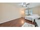 Bright bedroom featuring hardwood floors, large windows, a ceiling fan, and a desk area at 3605 Sapphire Sea Ct, North Las Vegas, NV 89031