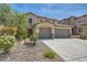 Inviting two-story home features a three-car garage and desert landscaping in the front yard at 3605 Sapphire Sea Ct, North Las Vegas, NV 89031