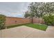 Private backyard with putting green, framed by a brick wall and mature landscaping at 3605 Sapphire Sea Ct, North Las Vegas, NV 89031