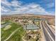 Expansive aerial view of a community offering golf, tennis, and swimming amenities amidst scenic landscapes at 44 Alta Cascata Pl, Henderson, NV 89011