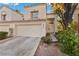 Two-story beige home with a two-car garage and landscaping at 2628 Starfish Ct, Las Vegas, NV 89128