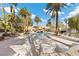 Community pool with lounge chairs and palm trees at 2628 Starfish Ct, Las Vegas, NV 89128