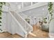 Modern white staircase with a metal railing overlooking the living area at 2628 Starfish Ct, Las Vegas, NV 89128