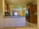 Open kitchen with tile flooring, bar, wood cabinets, and stainless steel refrigerator at 4036 Shetland Pony St, Las Vegas, NV 89122