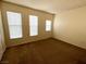 Well-lit bedroom with neutral carpet and three windows at 10550 W Alexander Rd # 2149, Las Vegas, NV 89129