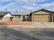 Tan one-story house with a two-car garage and red rock landscaping at 2529 Rialto Rd, Las Vegas, NV 89108