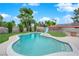 Beautiful backyard with a sparkling pool, lush lawn, and mature trees at 3690 S Rosecrest Cir, Las Vegas, NV 89121