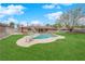 An expansive backyard with a beautiful pool, slide, and a lush green lawn at 3690 S Rosecrest Cir, Las Vegas, NV 89121