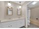 Bathroom with double vanity, mirrors, updated lighting, and bathtub with shower at 3690 S Rosecrest Cir, Las Vegas, NV 89121