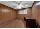 Bedroom with laminate floors, wood paneling, ceiling fan, and a built in desk at 3690 S Rosecrest Cir, Las Vegas, NV 89121